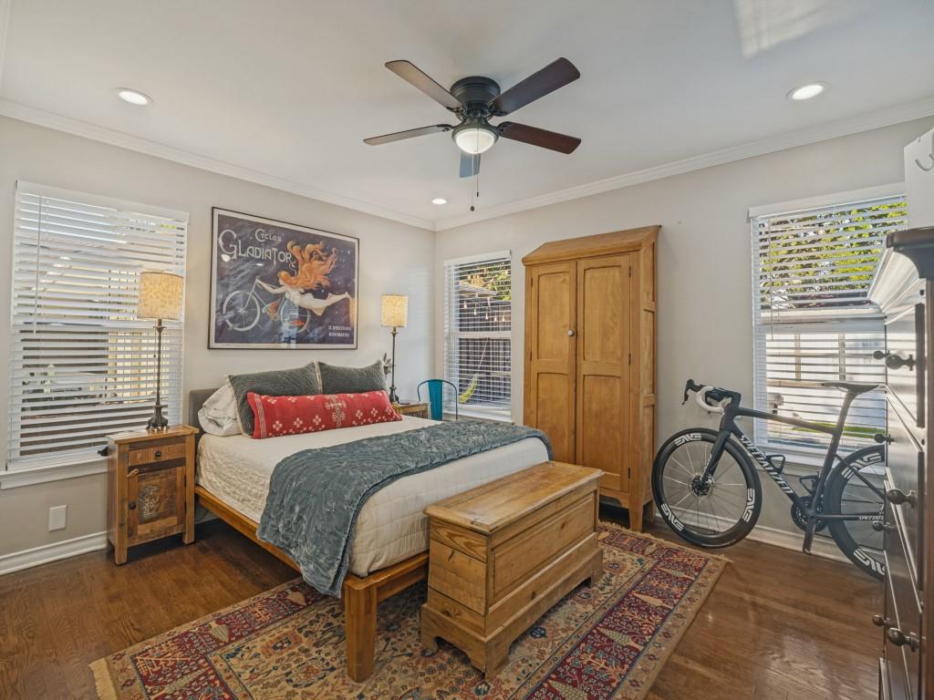 Wood-finish flooring, recessed lighting, ceiling fan, and multiple windows with horizontal blinds