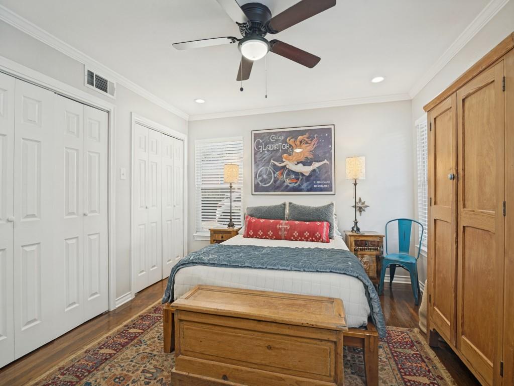 Wood-finish flooring, dual bi-fold door closets, recessed lighting, and a ceiling fan with integrated light fixture