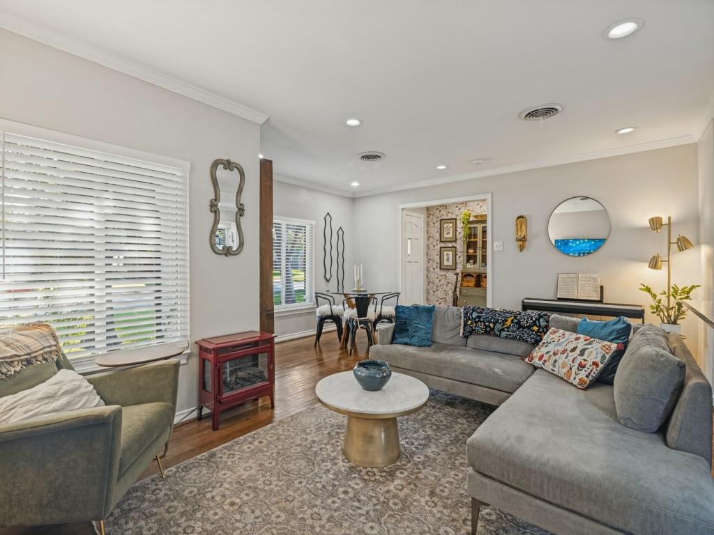 Living area featuring hardwood-finish flooring, recessed lighting, crown molding, and horizontal slat window blinds