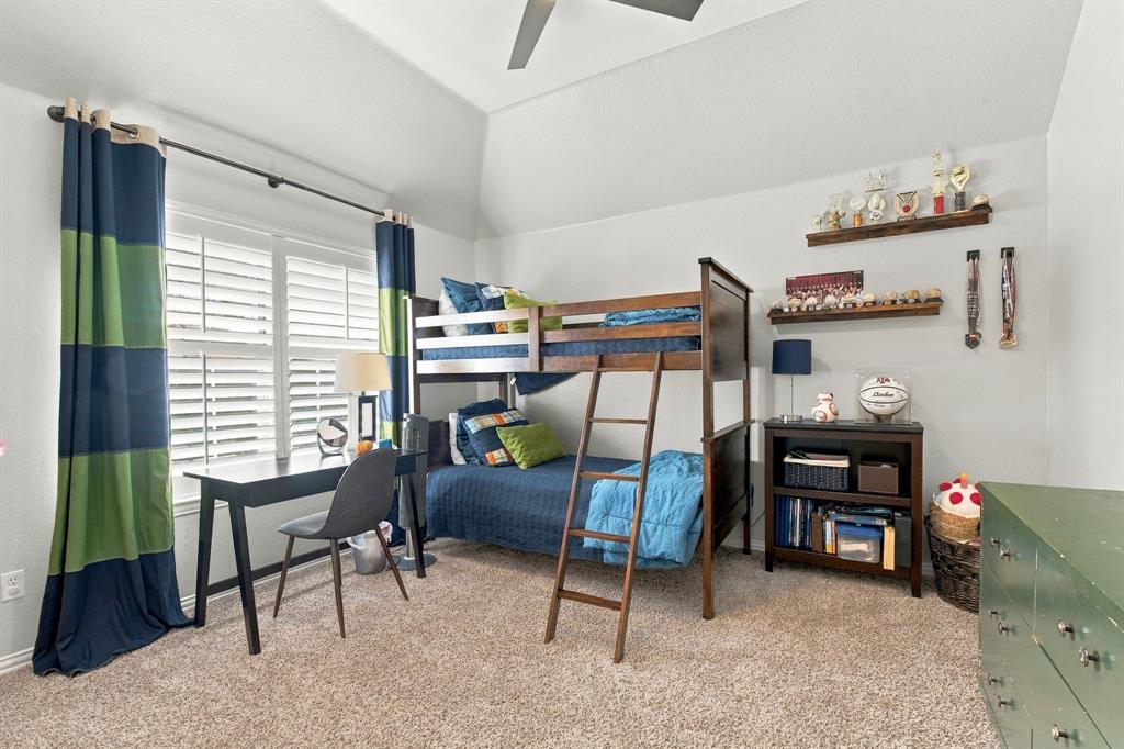 Vaulted ceilings, carpeted flooring, white plantation shutters, and a ceiling fan