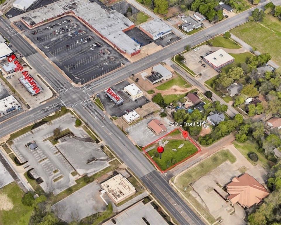 Corner parcel situated at a street intersection featuring direct road access, paved perimeter curbing, and level topography