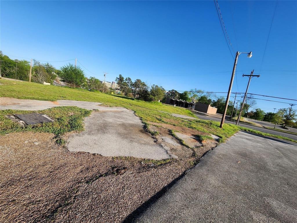 Expansive parcel of land featuring level topography, paved hardscaping, and established grass coverage Expansive parcel of land featuring level topography, paved hardscaping, and established grass coverage