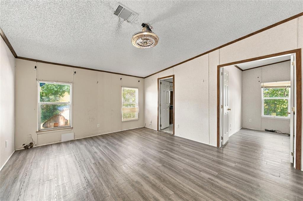 Interior space featuring wood-finish flooring, textured ceiling, two windows, and an attached overhead light fixture