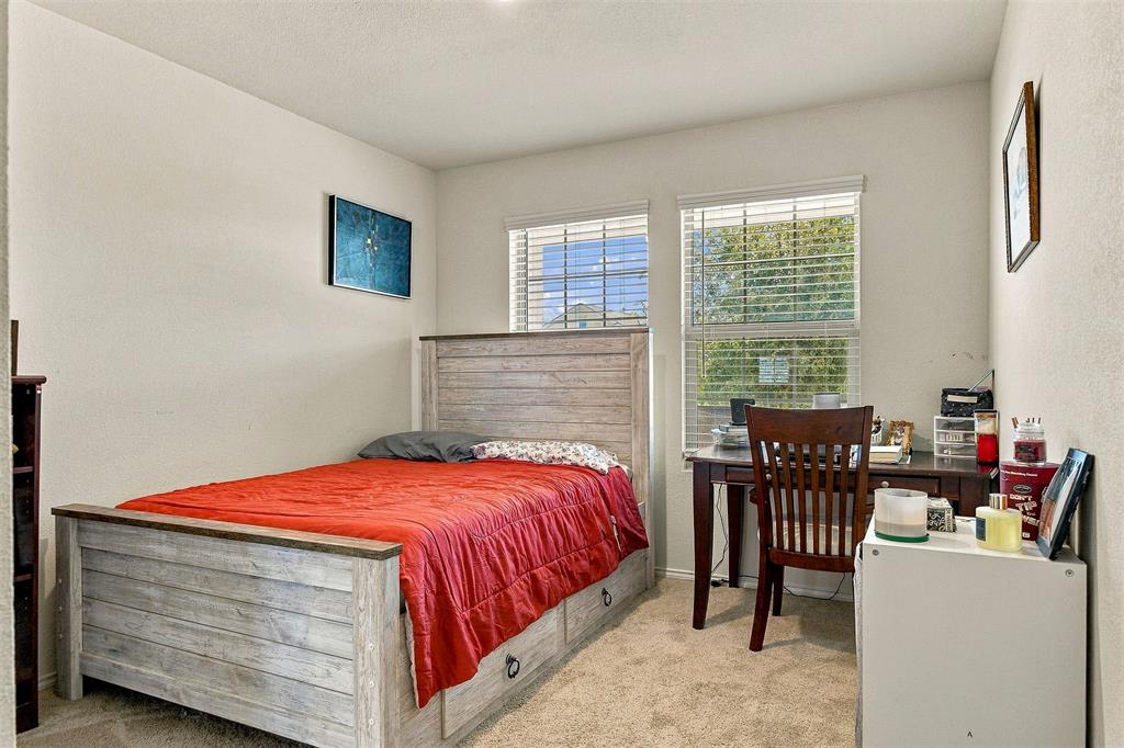 Neutral-toned interior space featuring light-colored wall-to-wall carpeting and two large windows with horizontal blinds