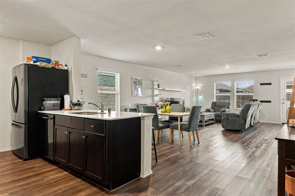 Spacious living area with wood-look flooring and an open layout connecting the dining area and kitchen.