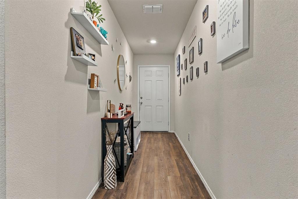 Entryway featuring wood-finish flooring, neutral wall tones, recessed lighting, and wall-mounted shelving