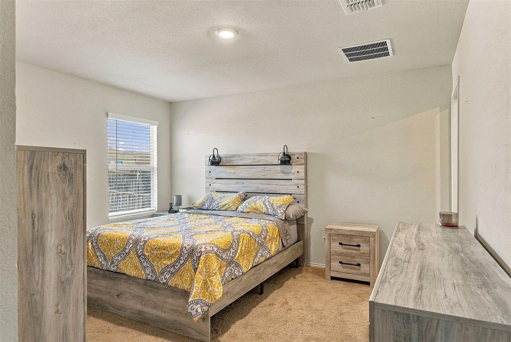 Neutral-toned walls, recessed lighting, and a single-hung window with horizontal blinds
