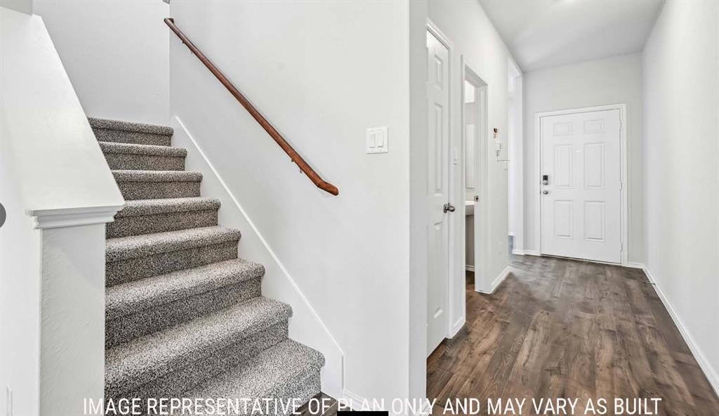 Entryway featuring wood-finish flooring, a carpeted staircase with a wood handrail, and a six-panel front door