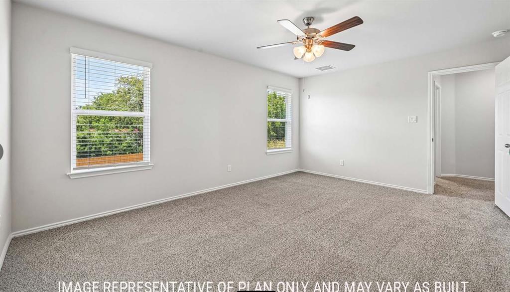 Neutral-toned carpeting, dual windows with horizontal blinds, and a ceiling-mounted light fixture with a fan