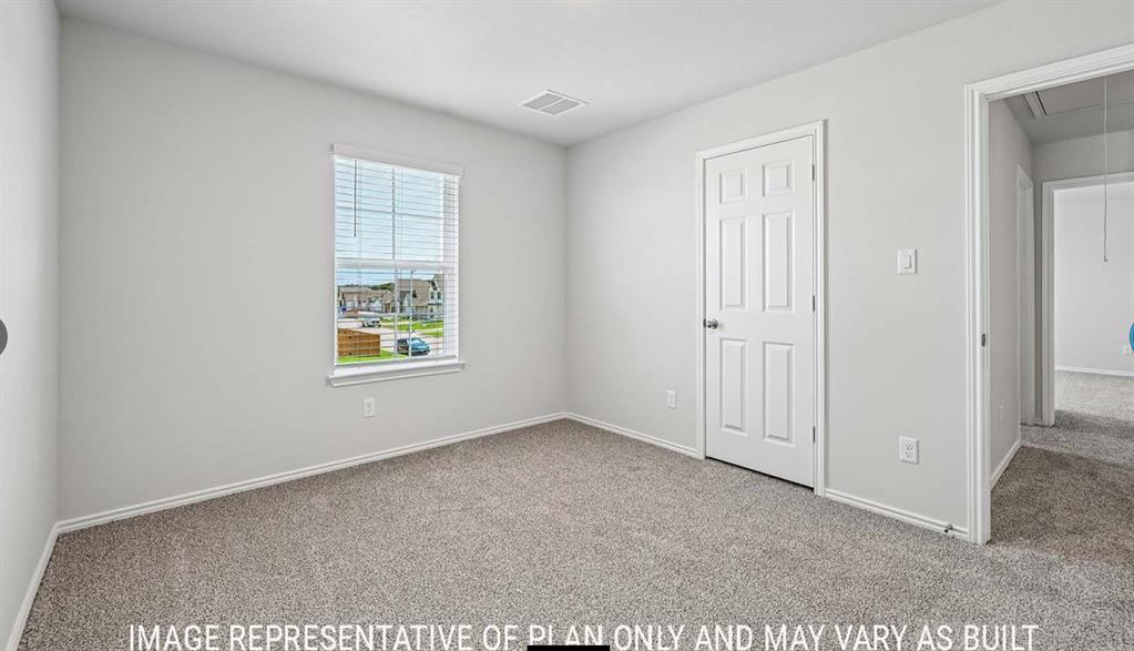Interior space featuring neutral wall paint, wall-to-wall carpeting, a single-hung window with a grid pattern, and a six-panel interior door
