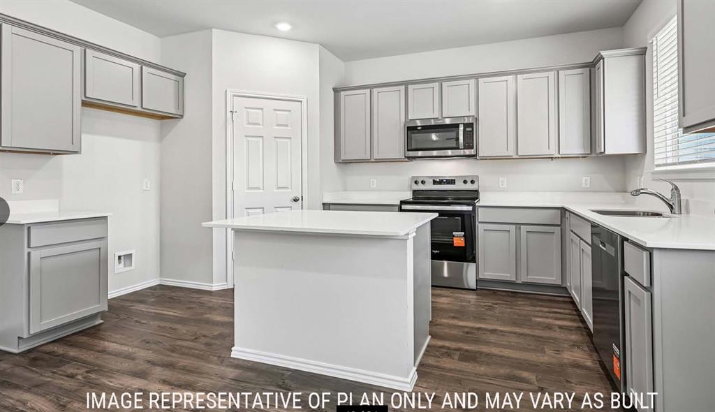 Kitchen featuring shaker-style cabinetry, quartz countertops, a central island, stainless steel appliances, and wood-finish flooring Kitchen featuring shaker-style cabinetry, quartz countertops, a central island, stainless steel appliances, and wood-finish flooring