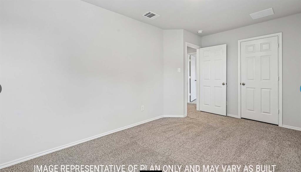 Neutral-toned interior featuring wall-to-wall carpeting, crisp white walls, and two six-panel swing doors