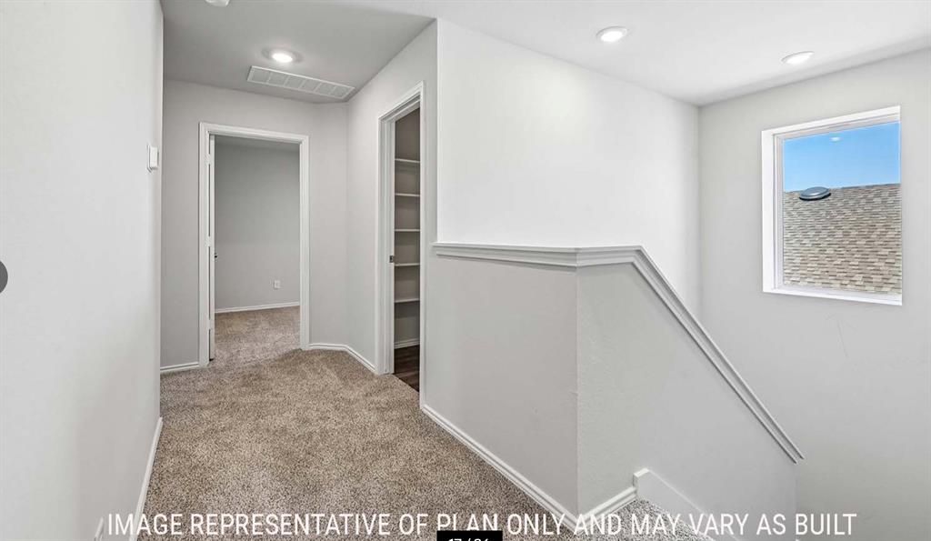 Neutral-toned carpeted hallway featuring recessed lighting, a built-in linen storage closet with shelving, and a square window