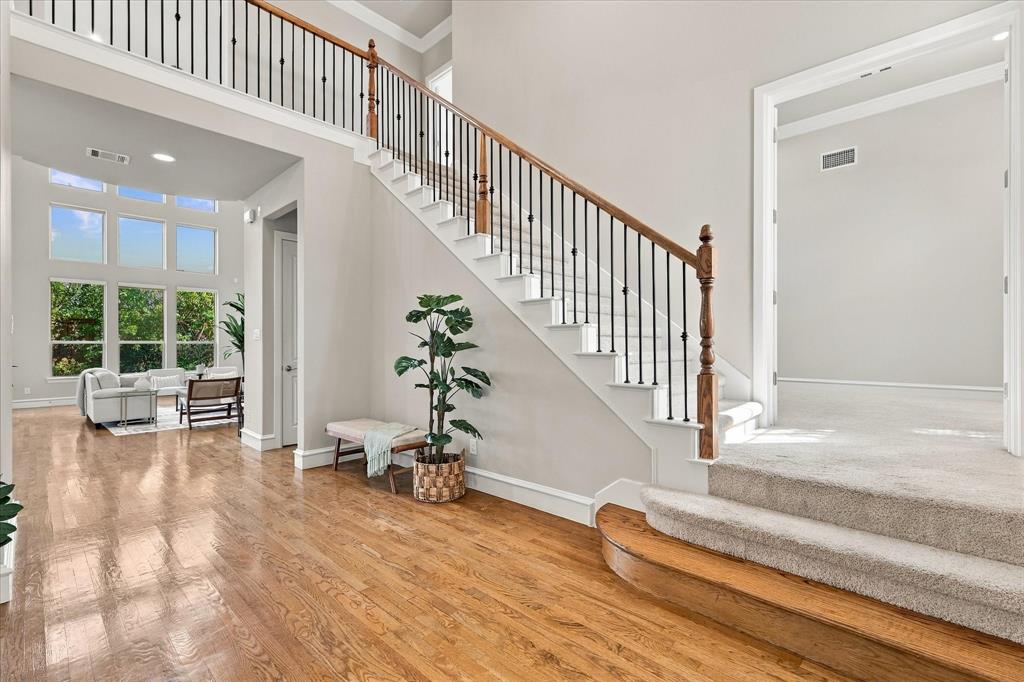 Beautiful entry with wood floors and rod iron staircase
