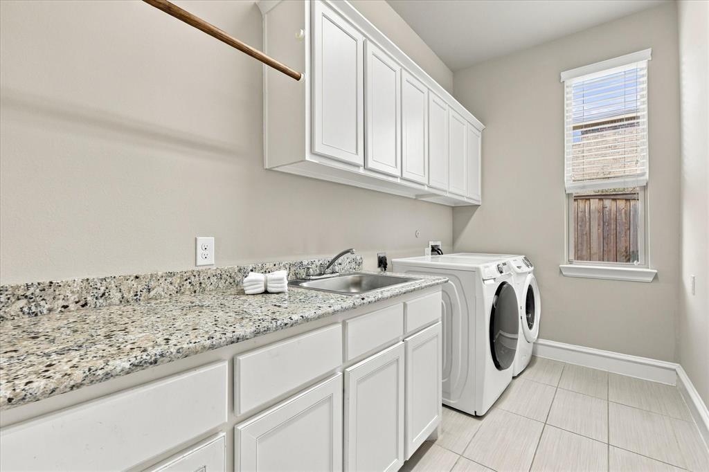 Oversized laundry room with granite counters, cabinets and sink