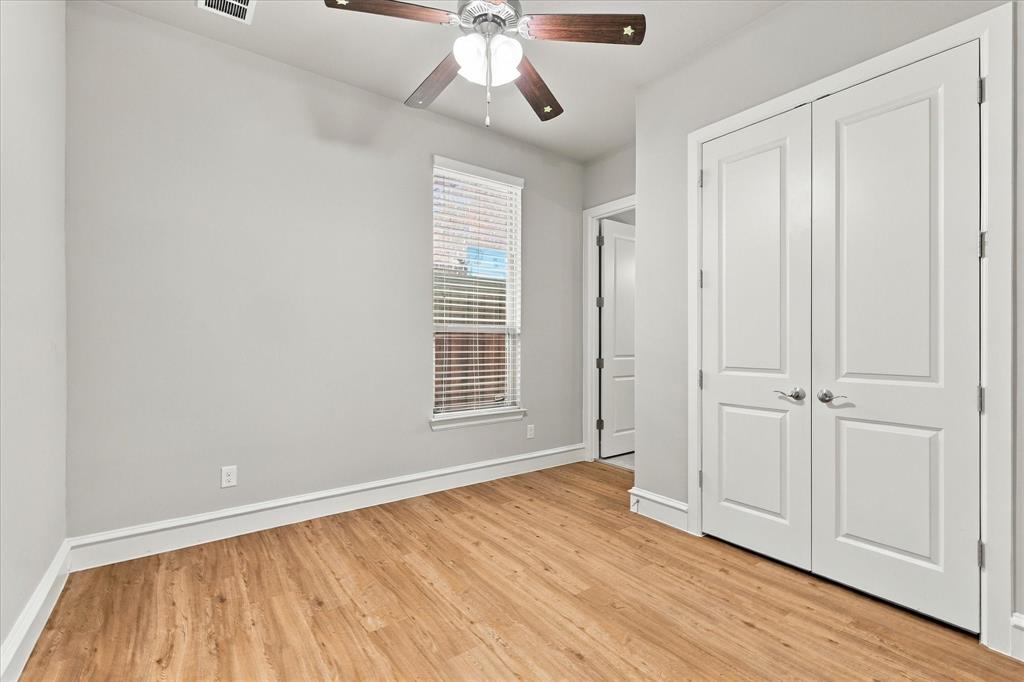 First floor secondary bedroom with wood floors and adjacent full bath