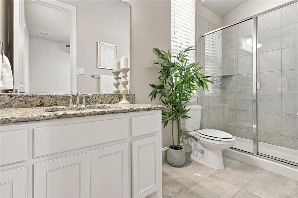 First floor guest bathroom with walk-in shower and granite counters