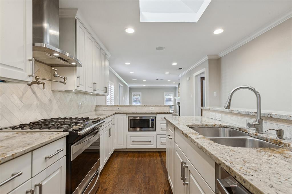 Fully-equipped kitchen has stainless appliances, custom cabs, and granite countertops