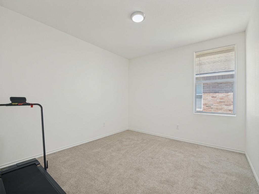Neutral-toned wall-to-wall carpeting, window with integrated blinds, and flush-mount ceiling lighting