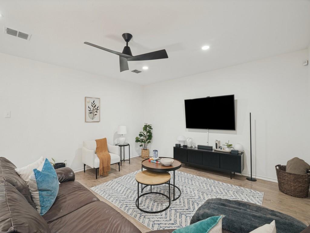 Interior space featuring wood-finish flooring, recessed lighting, and a matte black ceiling fan