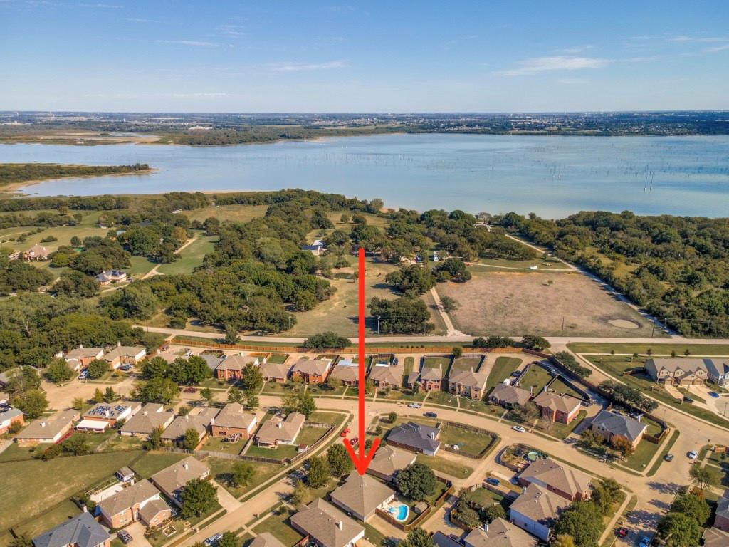 Aerial perspective featuring proximity to a large reservoir, expansive natural landscape, and residential setting with established vegetation