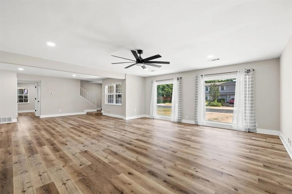 Open-concept interior featuring wood-finish flooring, recessed lighting, a ceiling fan, and large windows