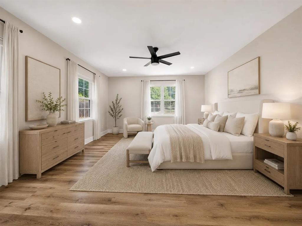 Neutral-toned interior featuring wood-finish flooring, recessed lighting, double-hung windows, and a matte black ceiling fan Neutral-toned interior featuring wood-finish flooring, recessed lighting, double-hung windows, and a matte black ceiling fan