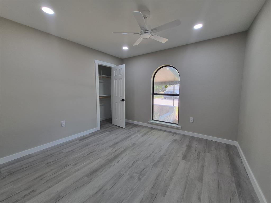 Interior space featuring wood-finish flooring, an arched window, recessed lighting, and a ceiling fan