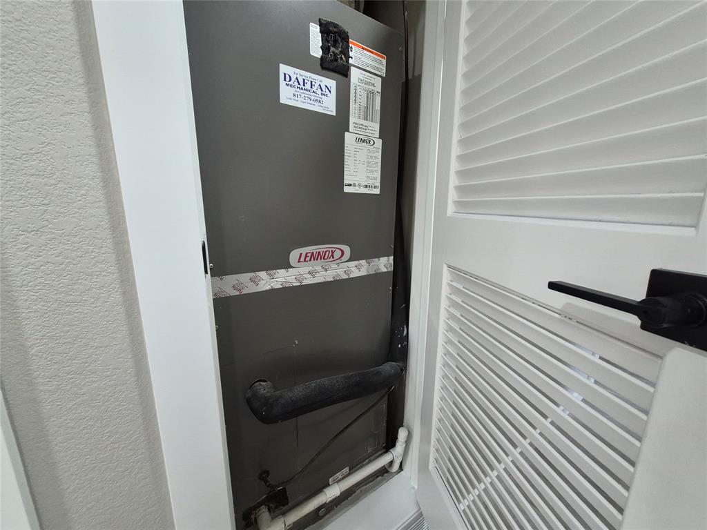 Lennox HVAC unit housed within a closet featuring a white louvered door and matte black hardware