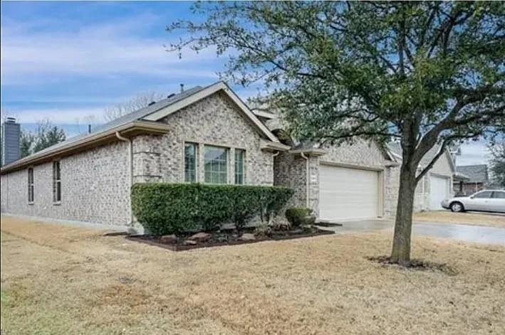 Single-story exterior featuring light-toned brick masonry, a multi-gabled roofline, an attached multi-car garage, and established landscaping Single-story exterior featuring light-toned brick masonry, a multi-gabled roofline, an attached multi-car garage, and established landscaping