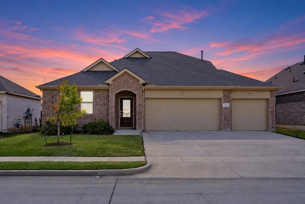 Brick and stone veneer facade featuring a multi-gabled roofline, concrete driveway, and attached two-car garage Brick and stone veneer facade featuring a multi-gabled roofline, concrete driveway, and attached two-car garage