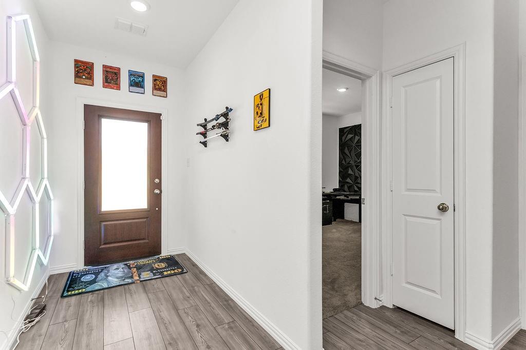 Entryway featuring a wood-finish door with an inset glass panel, recessed lighting, and vinyl flooring