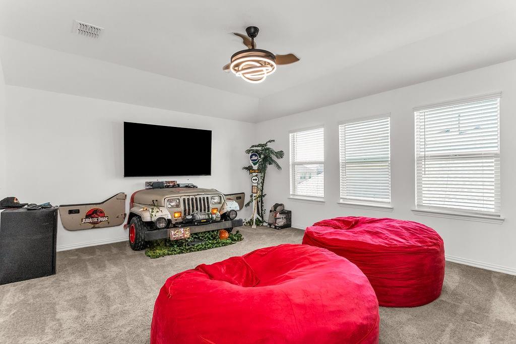 Tray ceiling, carpeted flooring, and modern circular LED ceiling fan with retractable blades