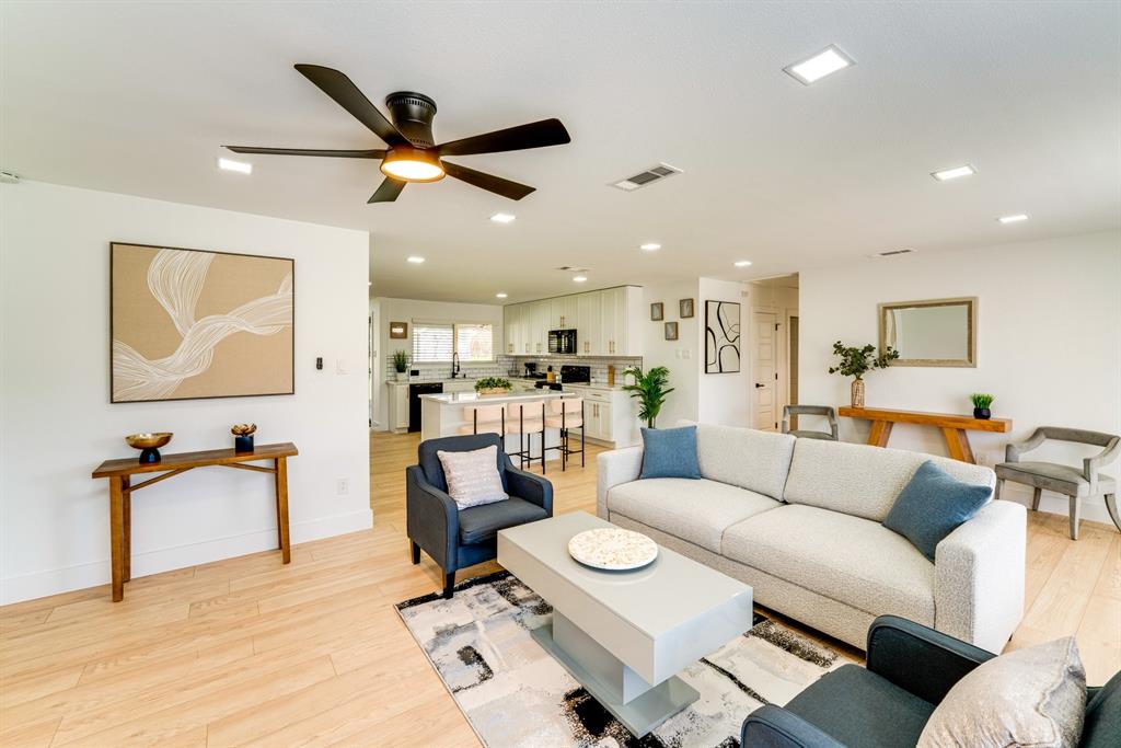 Open-concept living space featuring wood-finish flooring, recessed lighting, and a modern ceiling fan Open-concept living space featuring wood-finish flooring, recessed lighting, and a modern ceiling fan