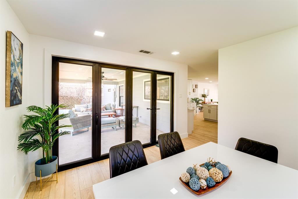 Black-framed glass folding doors, wood-finish flooring, and recessed ceiling lighting Black-framed glass folding doors, wood-finish flooring, and recessed ceiling lighting