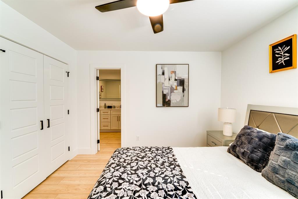 Wood-finish flooring, white paneled double-door closet, and ceiling fan with integrated lighting