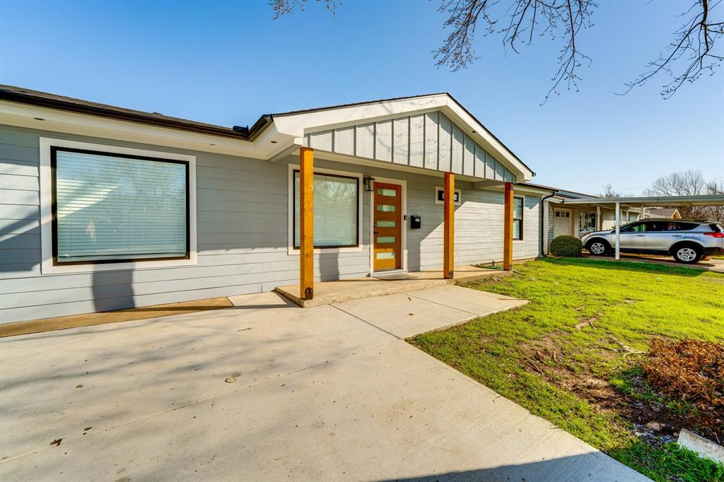 Exterior featuring horizontal siding, a covered porch with wood-finished support columns, a front entry door with glass inserts, and a detached carport Exterior featuring horizontal siding, a covered porch with wood-finished support columns, a front entry door with glass inserts, and a detached carport