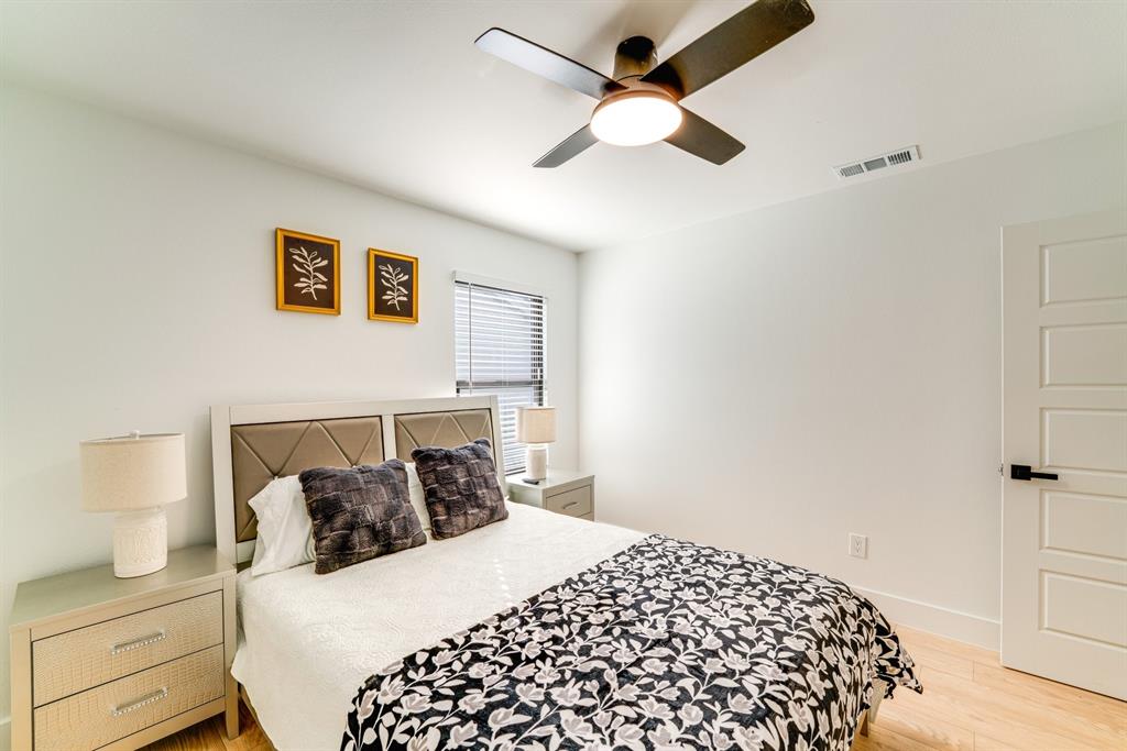 Room featuring light-toned wood-finish flooring, a modern ceiling fan with integrated lighting, and a five-panel interior door with matte black hardware