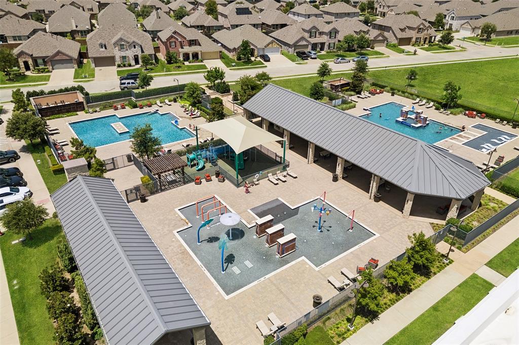 Community amenity center featuring multiple pools, a shaded play structure, and a dedicated splash pad