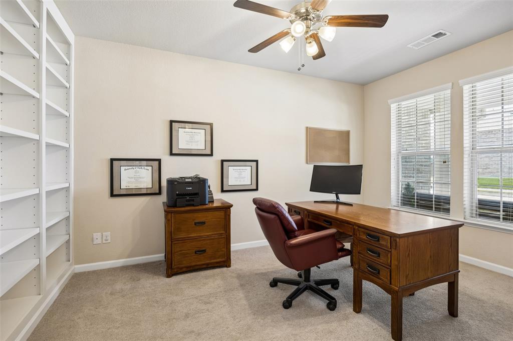 Dedicated home office with extensive built-in shelving and a ceiling fan Dedicated home office with extensive built-in shelving and a ceiling fan