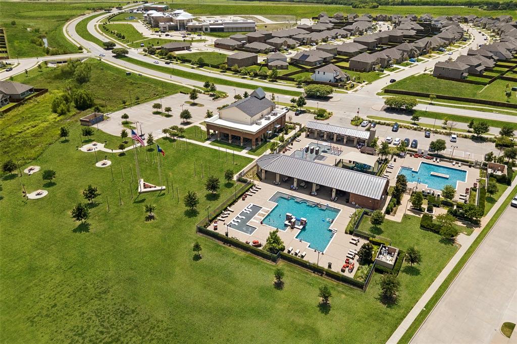 Community recreation area featuring multiple swimming pools, a covered outdoor lounge, and surrounding green spaces
