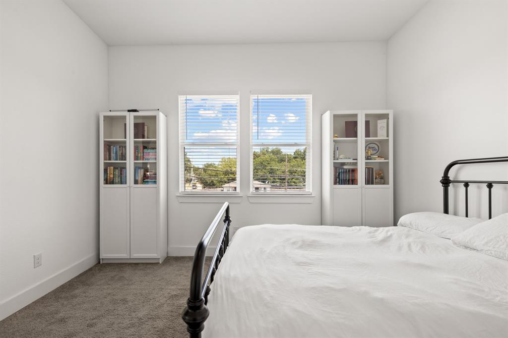 Bedroom with neutral carpeting, white walls, and two dual-pane windows providing natural light Bedroom with neutral carpeting, white walls, and two dual-pane windows providing natural light