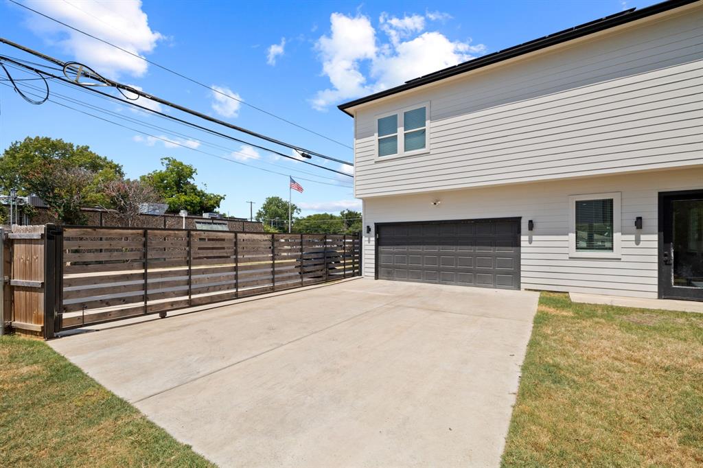 Exterior featuring horizontal siding, a multi-car garage with a paneled door, horizontal wood-slat privacy fencing, and a concrete driveway