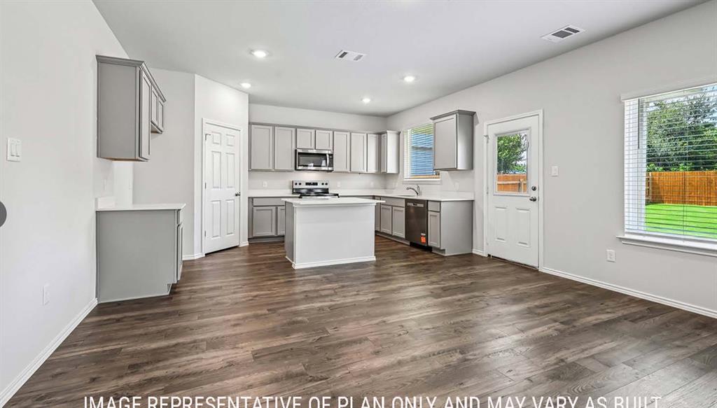 Kitchen featuring grey cabinetry, a central island, wood-finish flooring, recessed lighting, and a stainless steel appliance suite