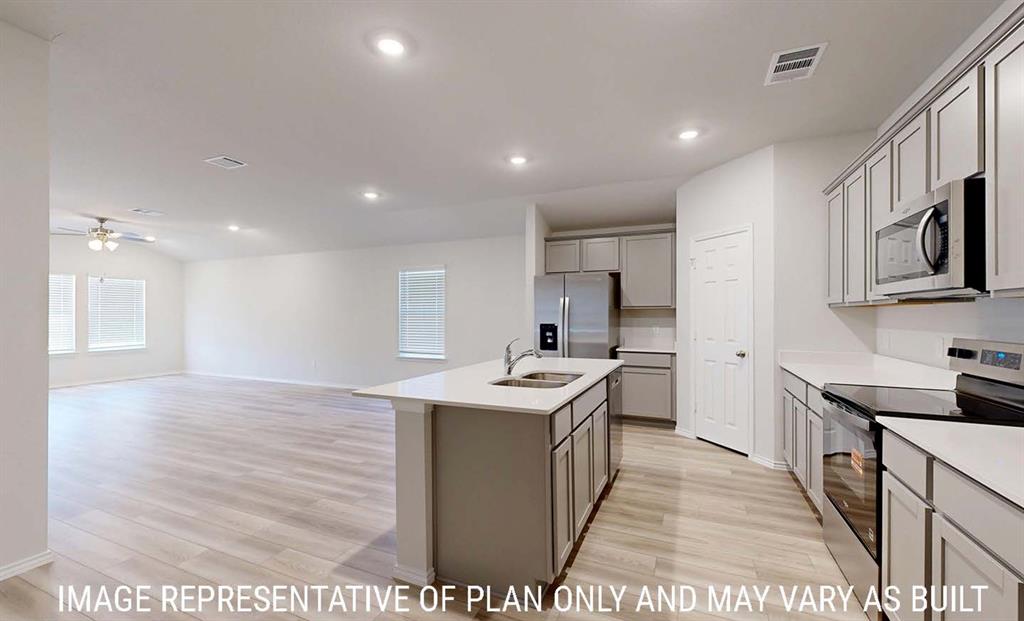 Kitchen featuring a center island, light-toned cabinetry, stainless steel appliances, and wood-finish flooring with recessed lighting Kitchen featuring a center island, light-toned cabinetry, stainless steel appliances, and wood-finish flooring with recessed lighting