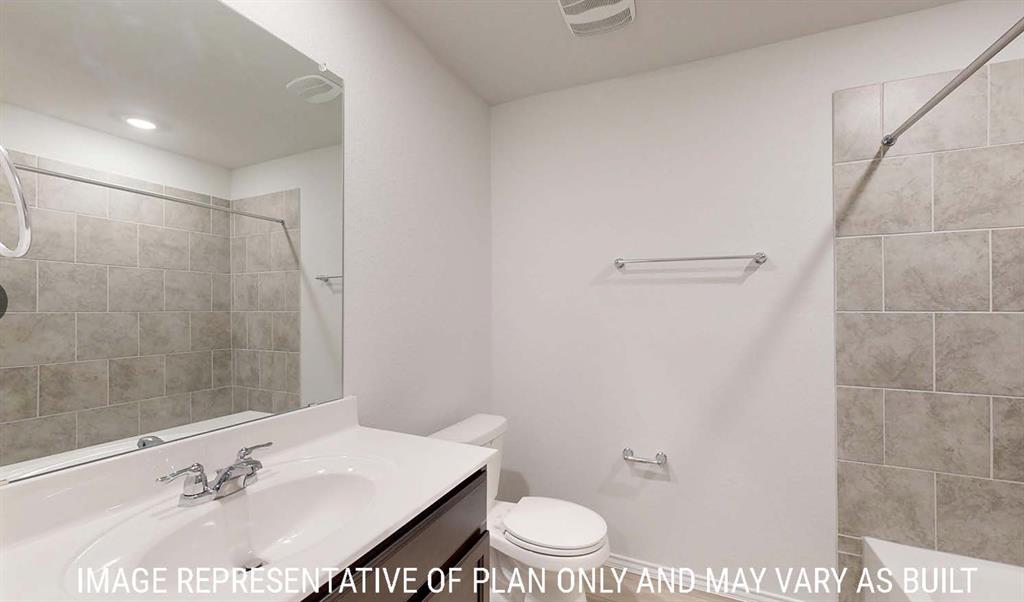 Bathroom featuring a dark-finish vanity with a white countertop, large wall-mounted mirror, and a tub with a grey tile surround