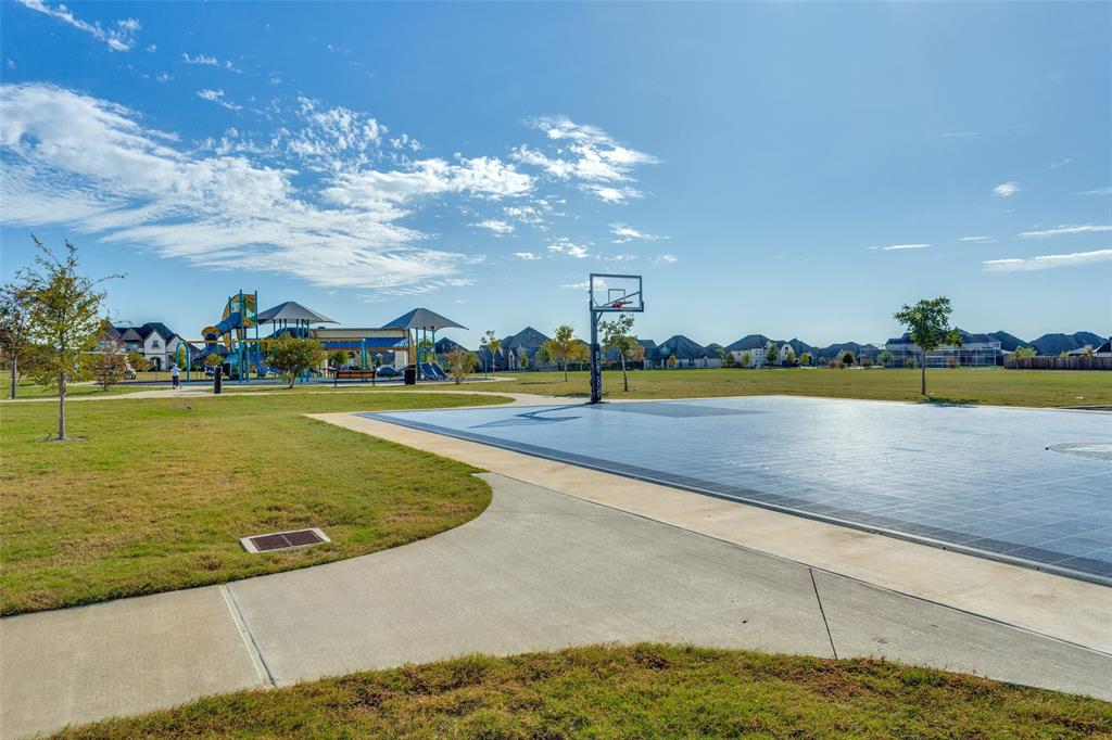 Community park with open green space, basketball and a playground.