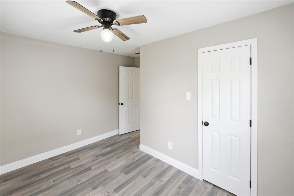Neutral wall finishes, wood-finish flooring, and a ceiling fan with integrated lighting