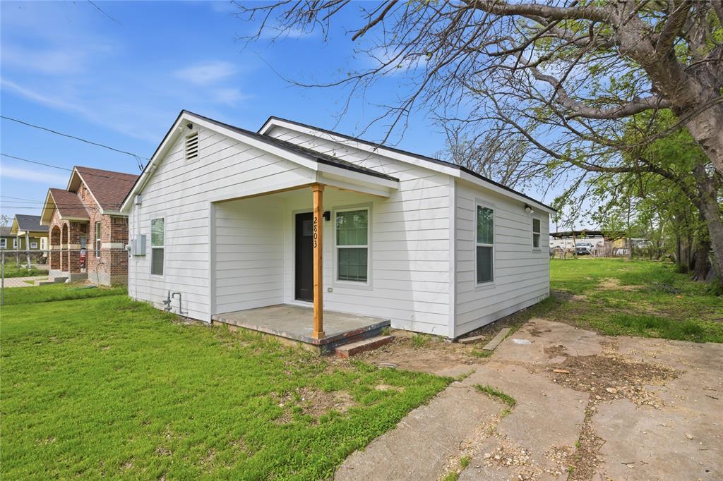 Exterior featuring horizontal white siding, a covered front porch with a wood support post, and a concrete driveway Exterior featuring horizontal white siding, a covered front porch with a wood support post, and a concrete driveway