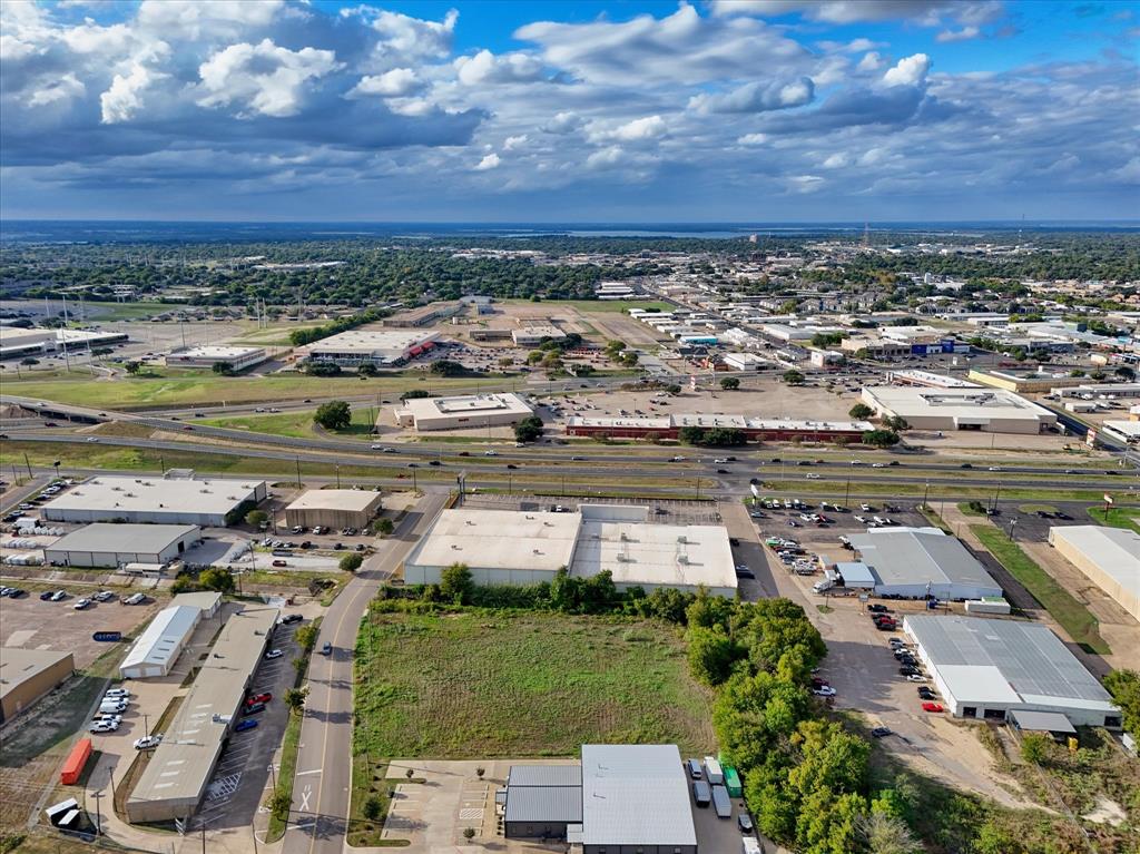 Aerial perspective of a corner lot featuring paved road access, frontage, and established regional infrastructure